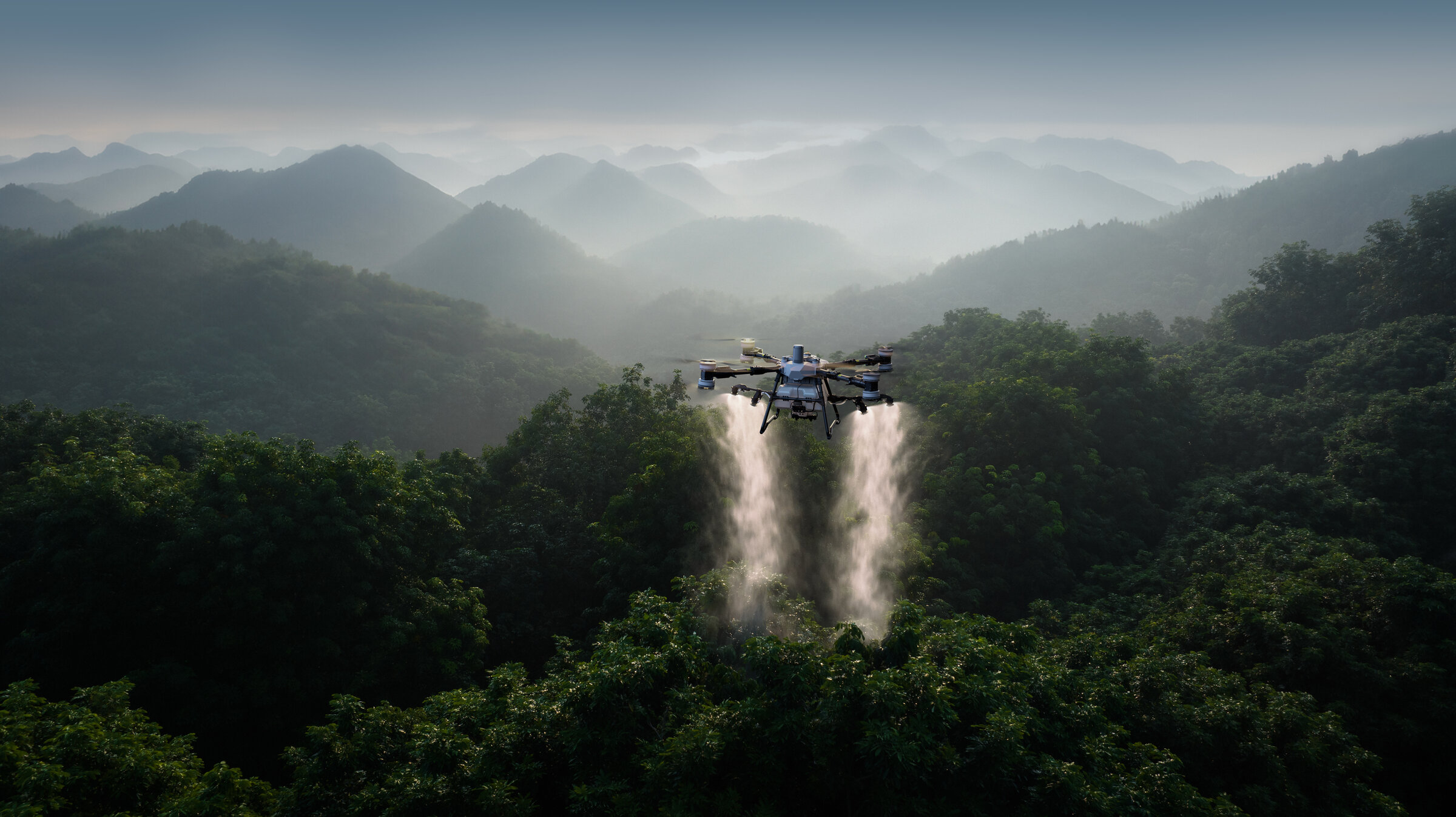 DJI Agras T100 spraying lychee orchard at dawn, mist over mountain valleys behind